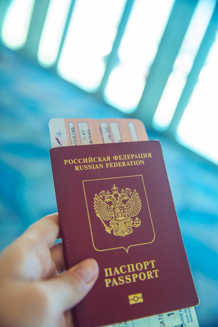 gallery-6 Russian passport held in hand with boarding pass peeking out, ready for travel.
