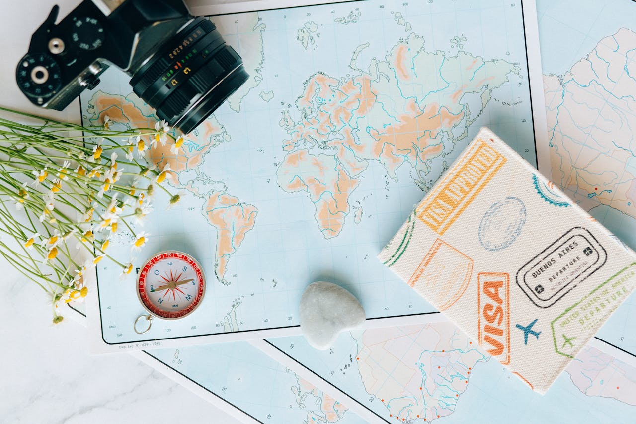 why-choose-us Flat lay of travel essentials: maps, camera, compass, and travel journal for planning adventures.